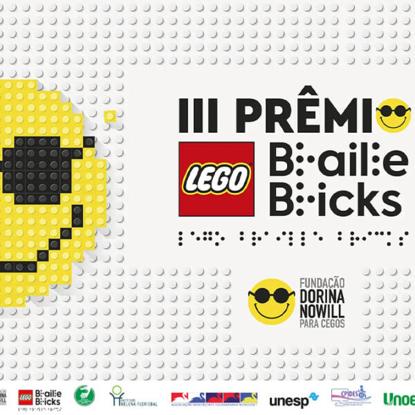 Painel com peças LEGO formando emoji sorridente com óculos escuros ao lado do título “III Prêmio LEGO Braille Bricks” e logotipo da Fundação Dorina Nowill para Cegos. (Créditos: Divulgação)