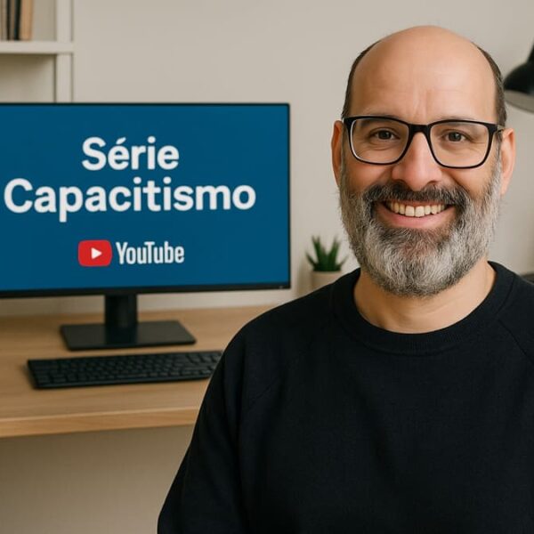 Avatar de Emílio Figueira criado por IA em escritório, ao lado de monitor que exibe o título “Série Capacitismo” e o logotipo do YouTube. (Créditos: Emílio Figueira)