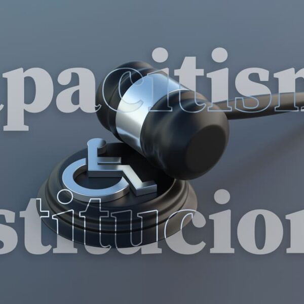 Martelo jurídico ao lado do símbolo de acessibilidade com texto capacitismo institucional. (Créditos: Depositphotos)