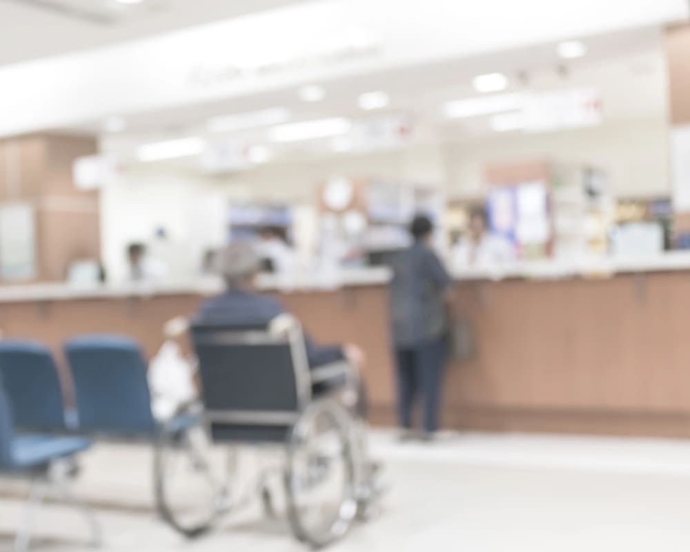 Pessoa em cadeira de rodas na recepção de um hospital, ilustrando a notícia sobre acompanhante para pacientes com deficiência.