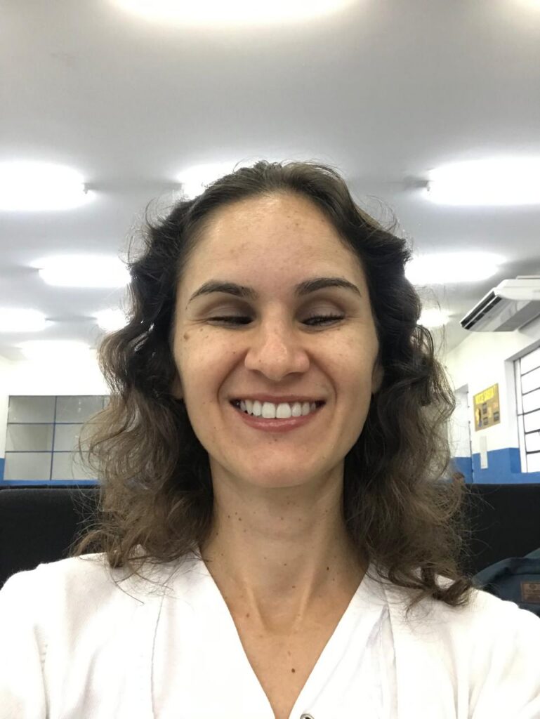 Foto de rosto de Mileide Moreira, autora do artigo. Ela é uma mulher com deficiência visual que sorri amplamente para a câmera.