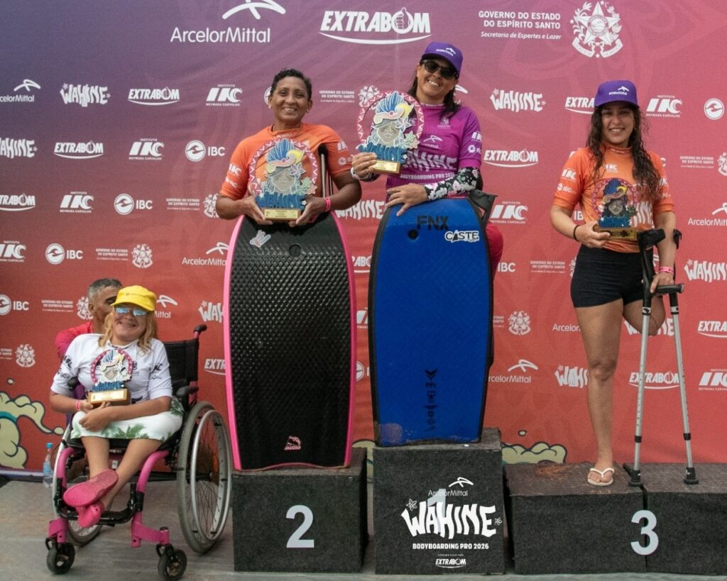 Pódio da categoria PCD no Wahine Bodyboarding Pro com quatro atletas com deficiência segurando troféus e pranchas.